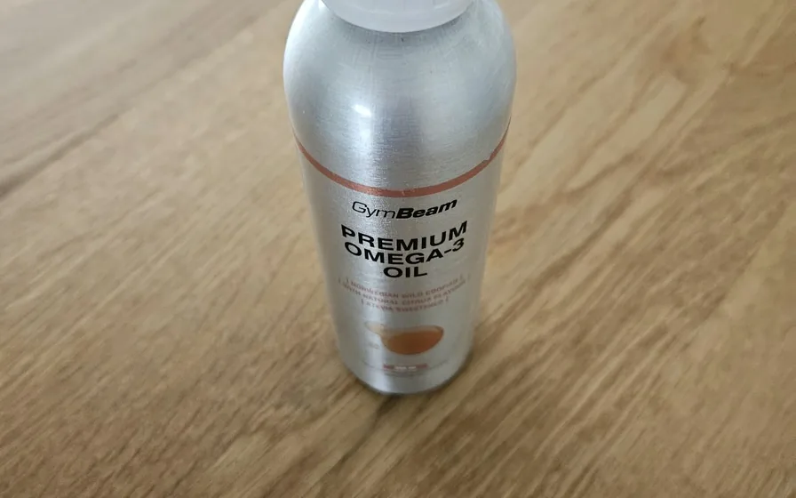 Metallflasche GymBeam Premium Omega-3 Oil mit 250 ml auf einem Holztisch