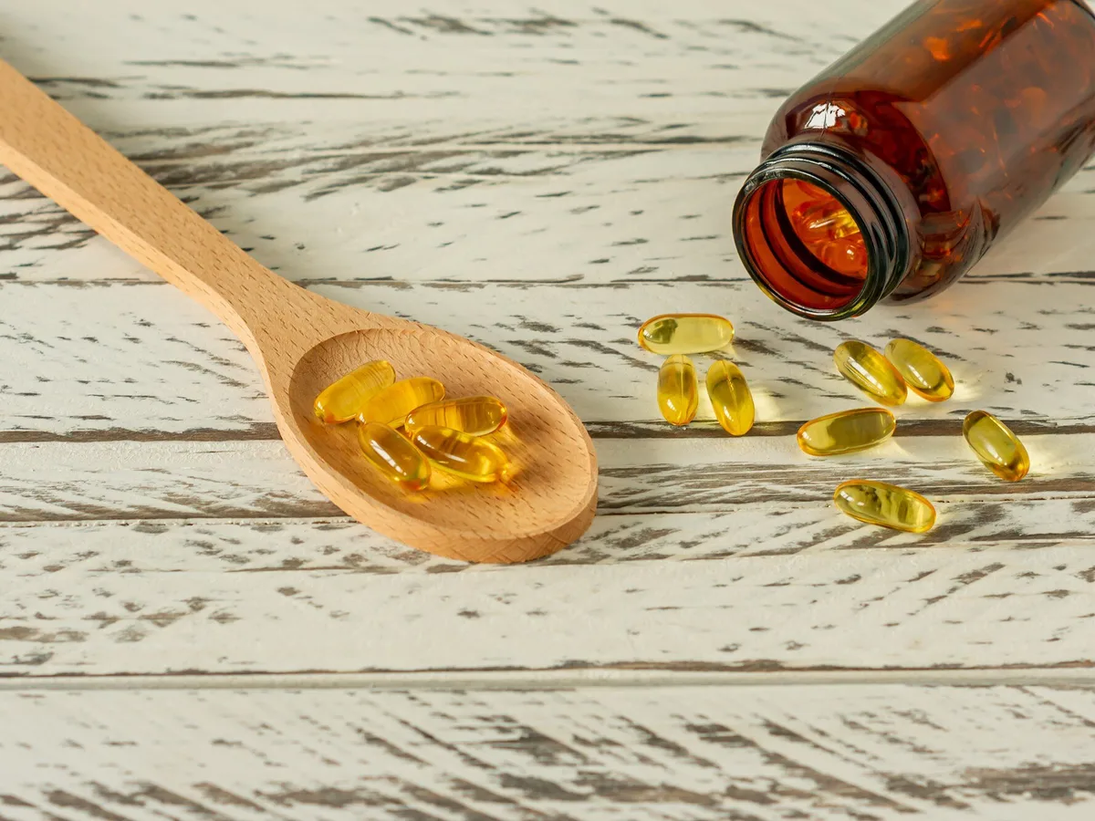 Goldene Omega-3-Kapseln auf Holzuntergrund