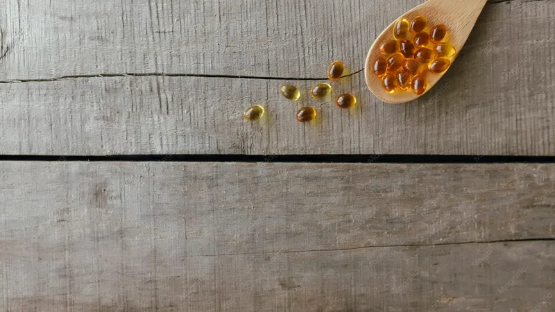 Omega-3-Kapseln und Dosierlöffel auf hellem Hintergrund